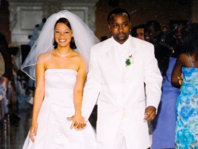 Rena Frazier and Anddrikk Frazier are in their wedding dress, holding hands and walking.